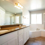 Remodeled bathroom showing brown granite countertop.
